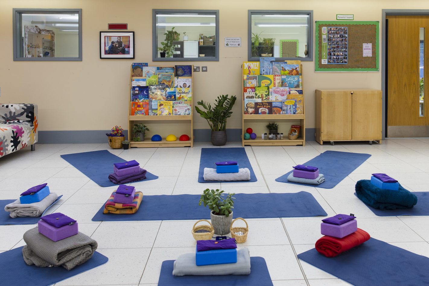 A large brightly lit room with yoga mats laid out in a circle